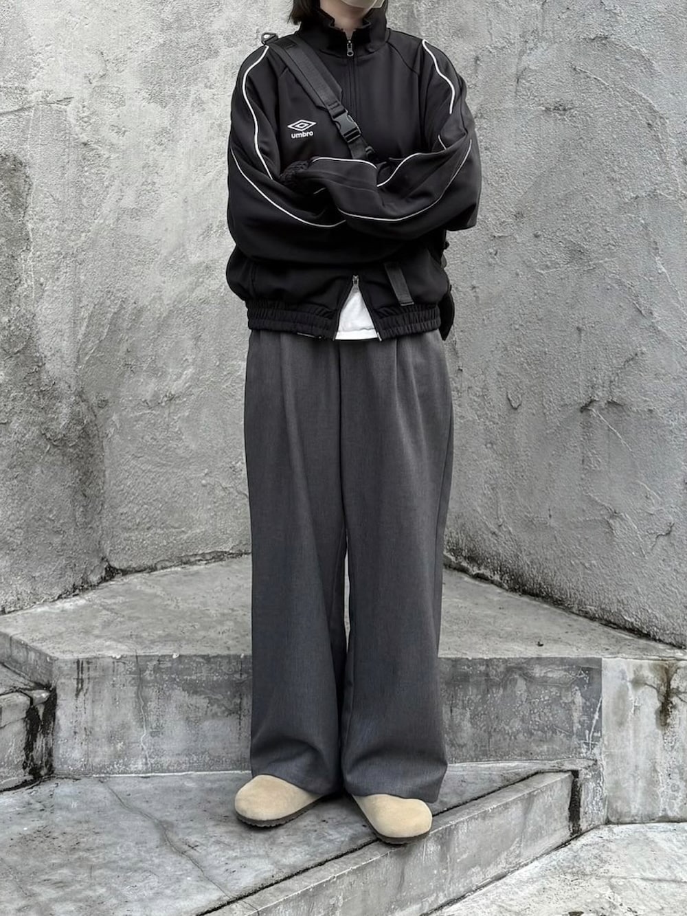 ブラック系のその他アウター、グレー系のスラックス、ベージュ系のサンダルを着用したレディースの春コーディネートの2枚目の写真