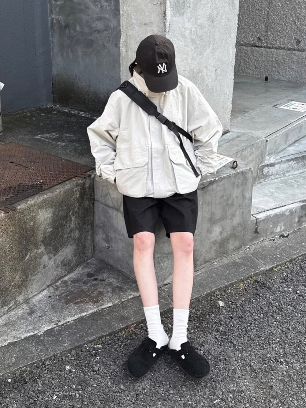 ホワイト系のマウンテンパーカー、ブラック系のその他パンツ、ブラック系のサンダルを着用したレディースの春コーディネートの2枚目の写真