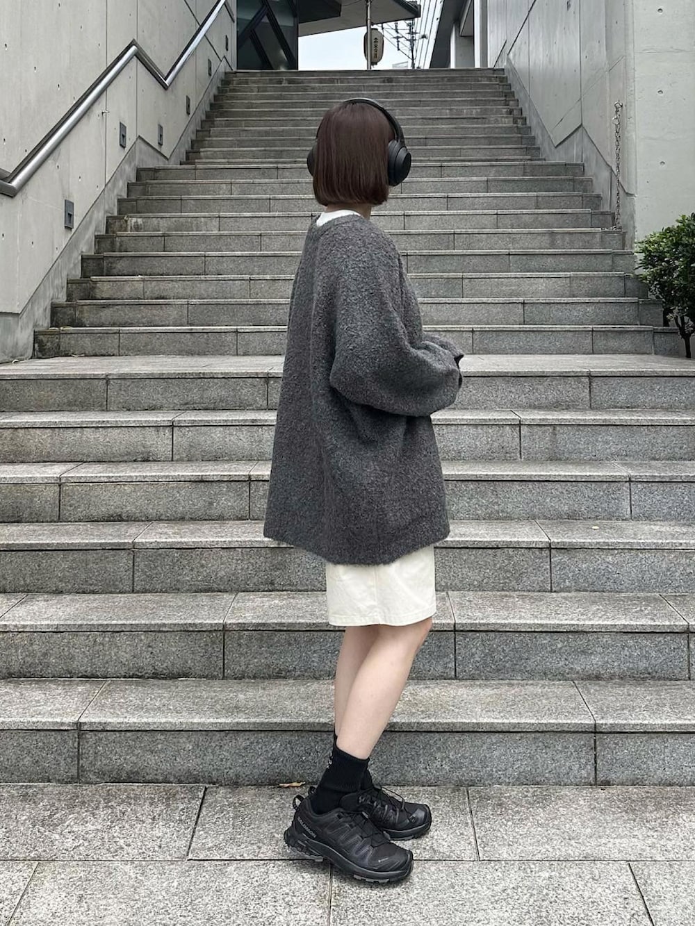 グレー系のカーディガン/ボレロ、ホワイト系のその他パンツ、ブラック系のスニーカーを着用したレディースの秋コーディネートの2枚目の写真