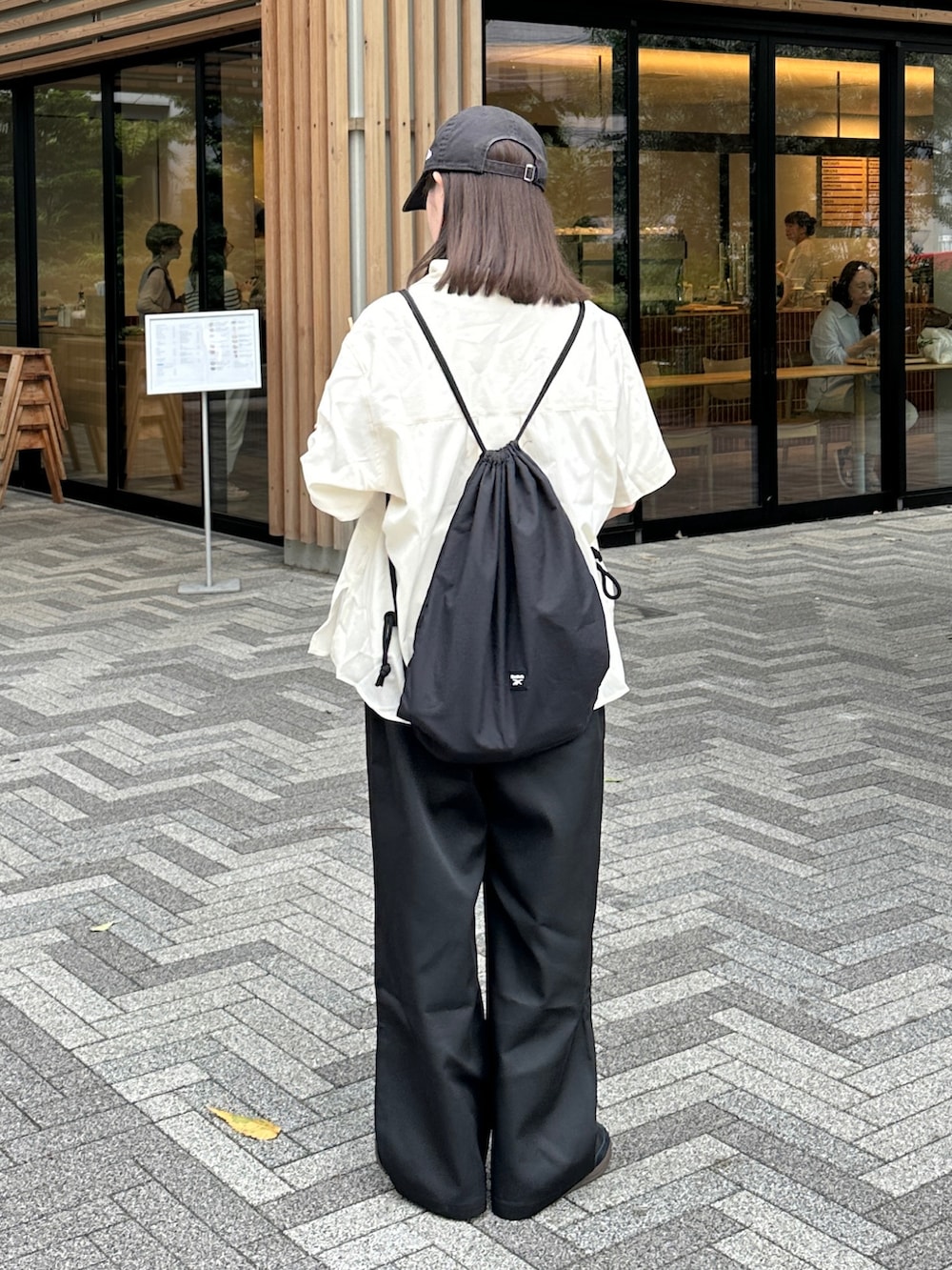 ホワイト系のシャツ/ブラウス、ブラック系のチノパンツ、ブラック系のショルダーバッグを着用したレディースの夏コーディネートの2枚目の写真