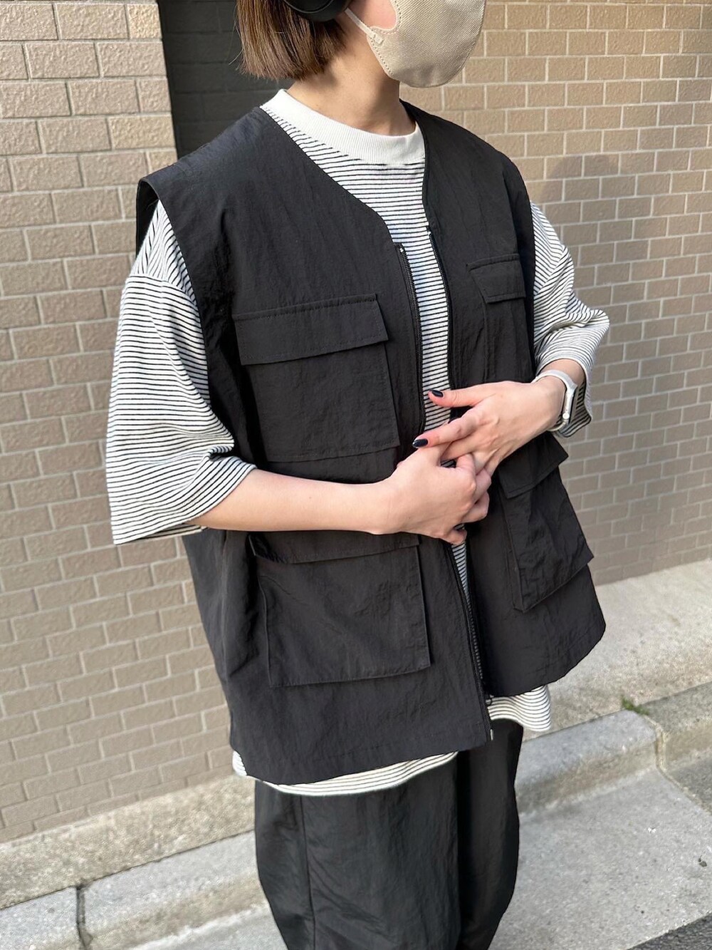 ホワイト系のTシャツ/カットソー、ブラック系のベスト、ブラック系のその他パンツを着用したレディースの春コーディネートの3枚目の写真