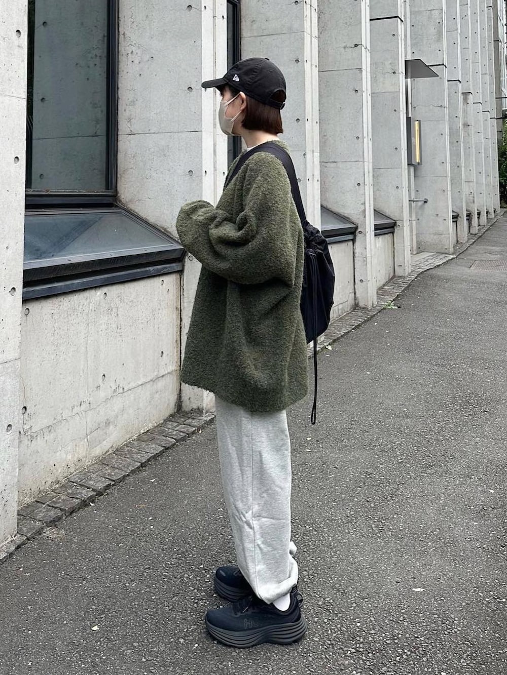 グリーン系のカーディガン/ボレロ、グレー系のスウェットパンツ、ブラック系のスニーカーを着用したレディースの秋コーディネートの2枚目の写真
