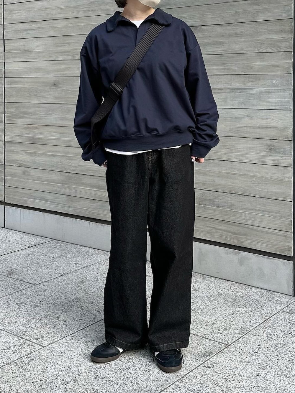 ブルー系のスウェット、ブラック系のデニムパンツ、ブラック系のショルダーバッグを着用したレディースの冬コーディネートの2枚目の写真