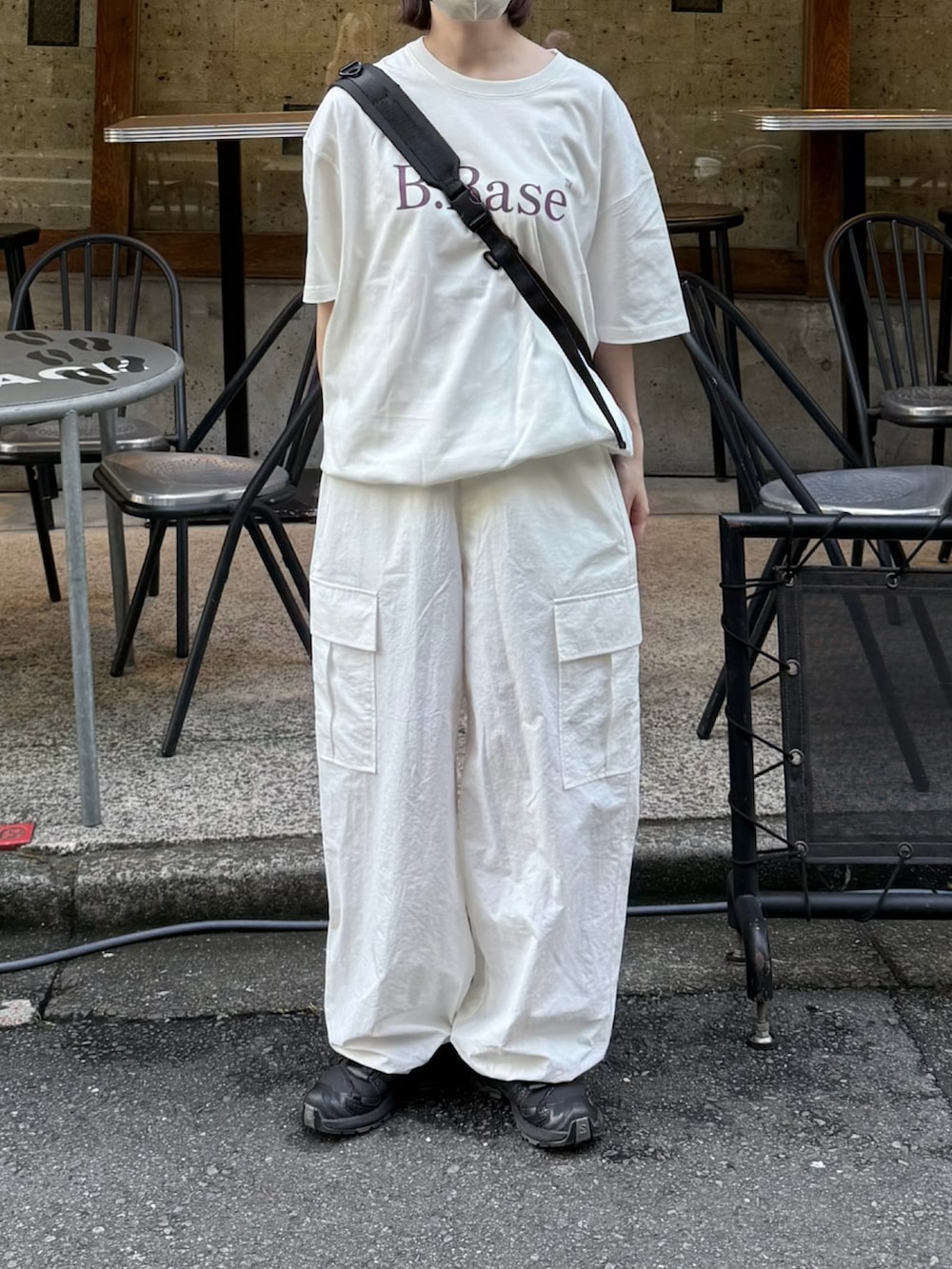 ホワイト系のTシャツ/カットソー、ブラック系のスニーカー、ホワイト系のカーゴパンツを着用したレディースの夏コーディネートの2枚目の写真