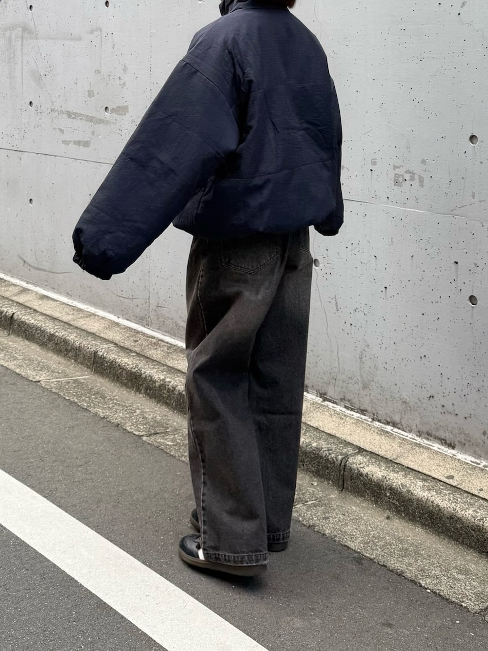 ブルー系のダウンジャケット/コート、ブラック系のデニムパンツ、ブラック系のスニーカーを着用したレディースの冬コーディネートの2枚目の写真