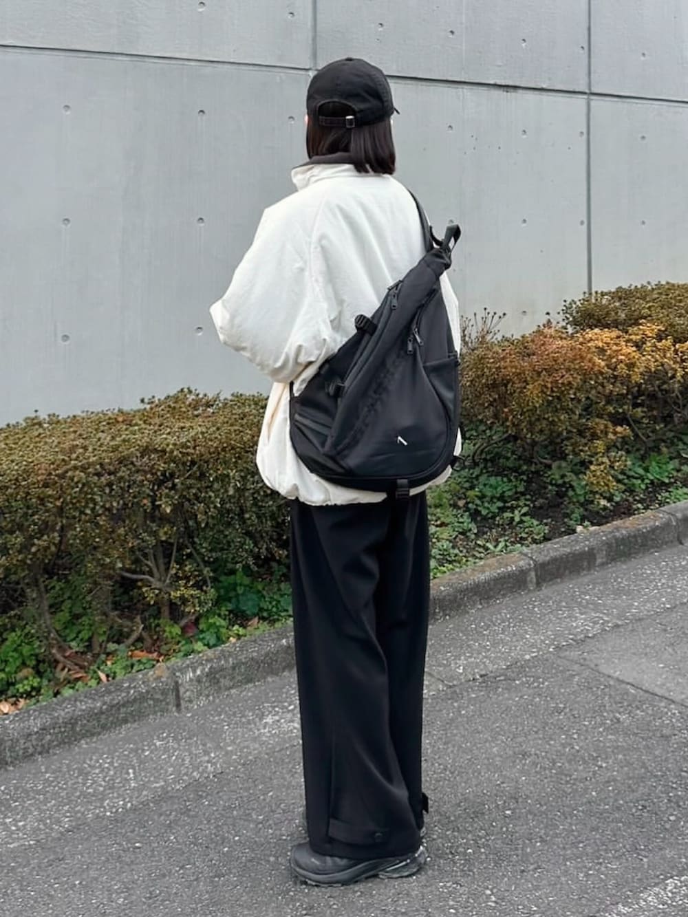 ホワイト系のその他アウター、ブラック系のスラックス、ブラック系のショルダーバッグを着用したレディースの冬コーディネートの3枚目の写真