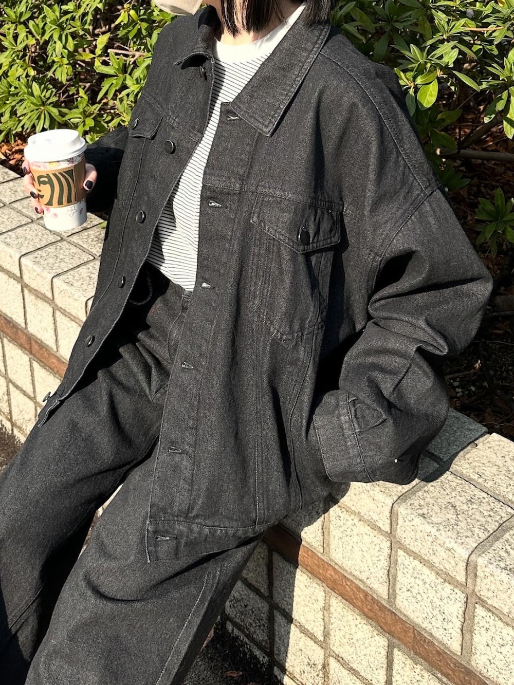 ブラック系のデニムジャケット、ブラック系のデニムパンツ、ホワイト系のTシャツ/カットソーを着用したレディースの春コーディネートの3枚目の写真