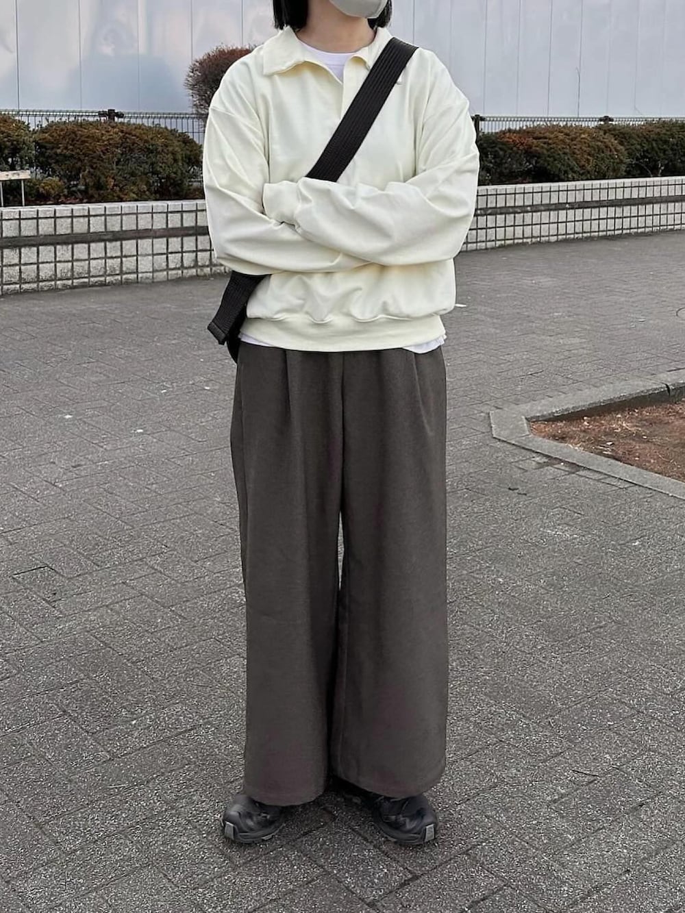 ホワイト系のスウェット、ブラウン系のスラックス、ブラック系のショルダーバッグを着用したレディースの冬コーディネートの2枚目の写真