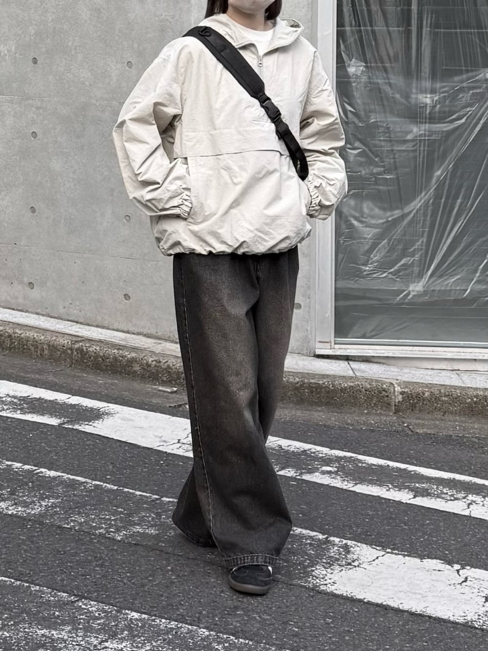 ホワイト系のパーカー、ブラック系のデニムパンツ、ブラック系のスニーカーを着用したレディースの春コーディネートの2枚目の写真