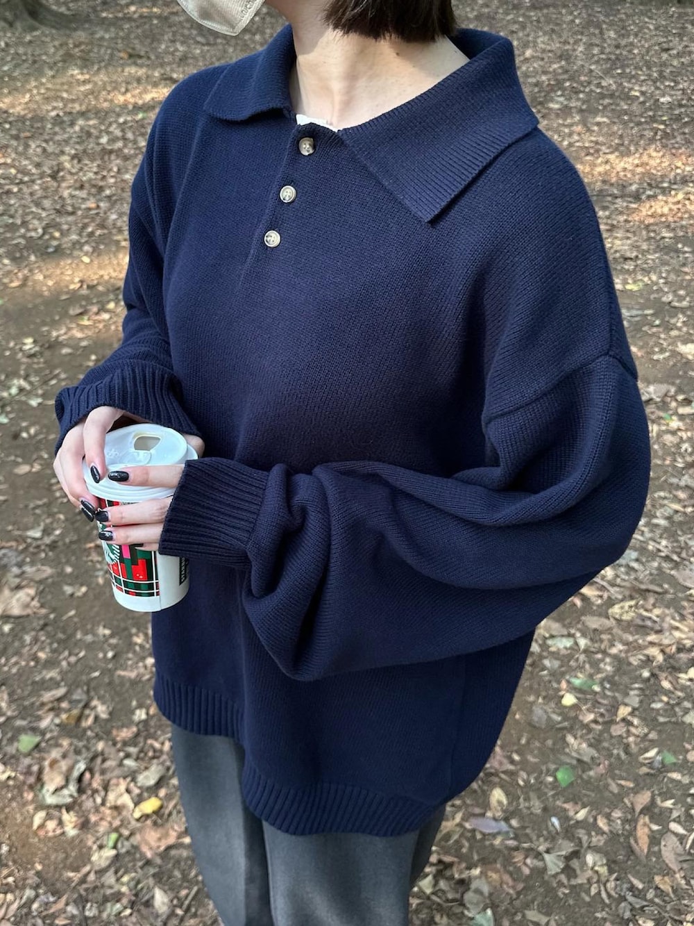 ブルー系のポロシャツ、グレー系のスラックス、ブラック系のスニーカーを着用したレディースの秋コーディネートの2枚目の写真