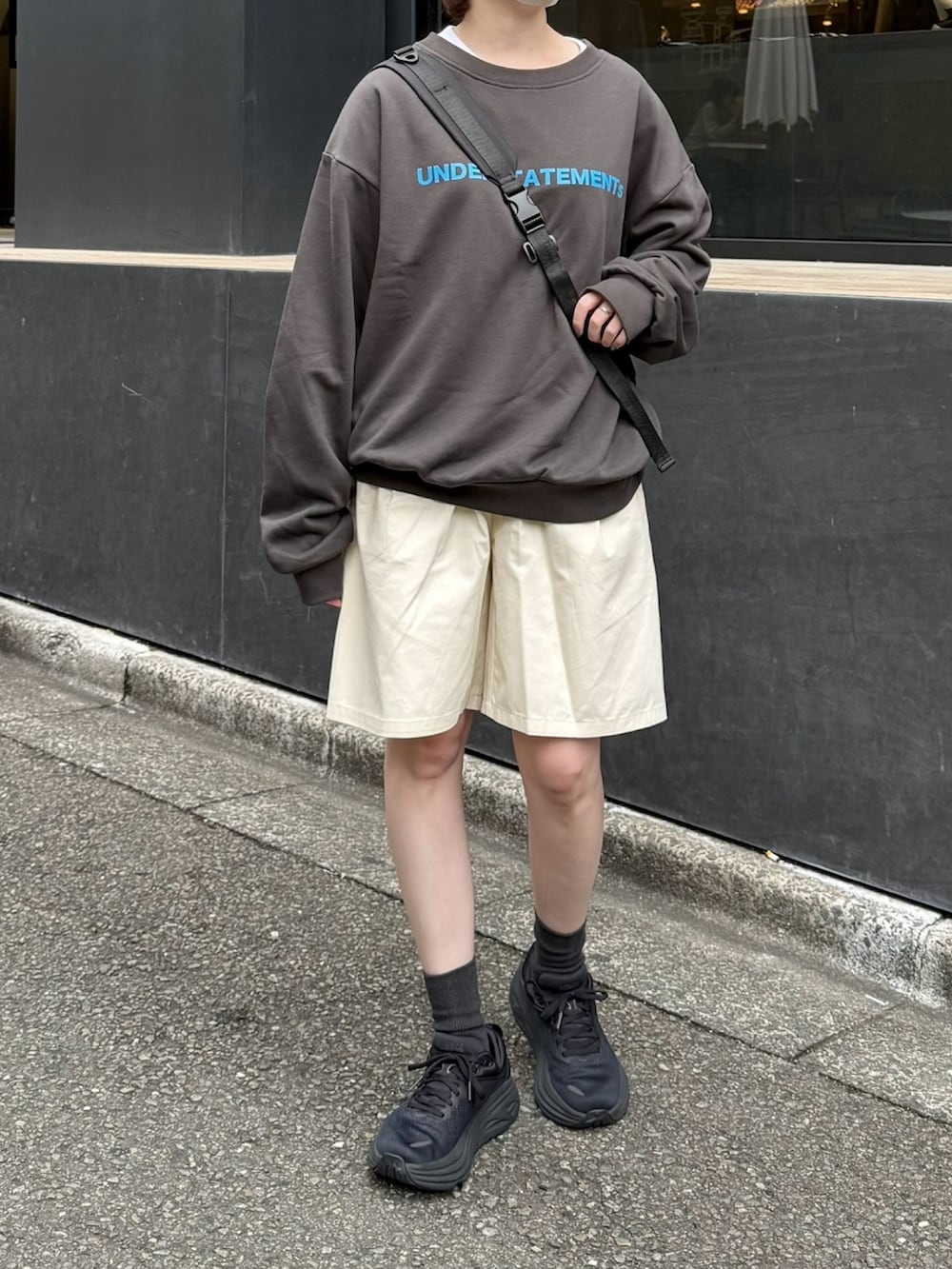 グレー系のスウェット、ホワイト系のその他パンツ、ブラック系のショルダーバッグを着用したレディースの秋コーディネートの2枚目の写真