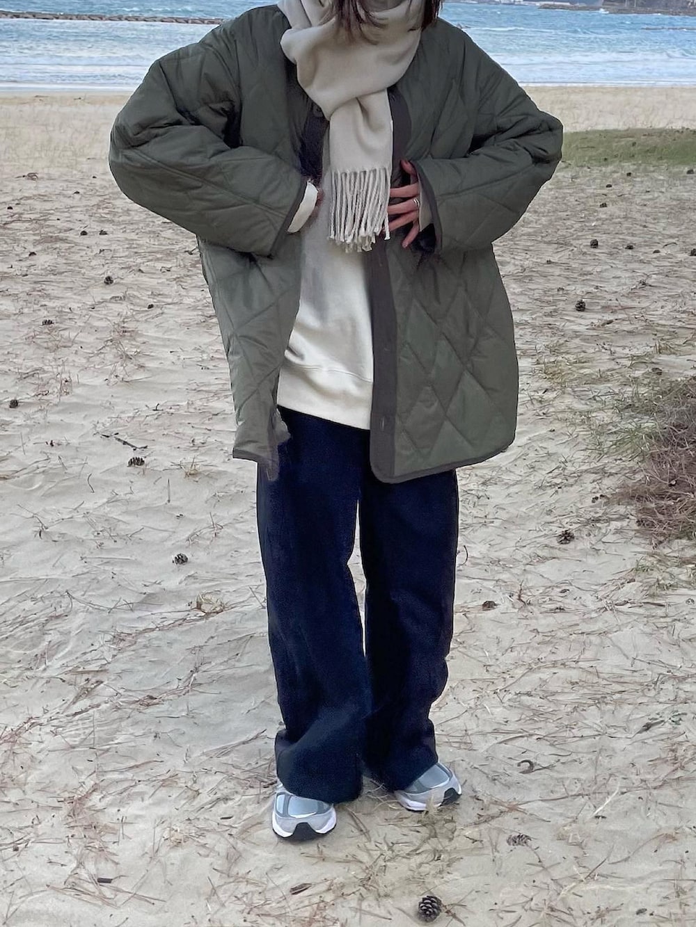 グリーン系のミリタリージャケット、ブラック系のその他パンツ、ベージュ系のマフラーを着用したレディースの冬コーディネートの2枚目の写真