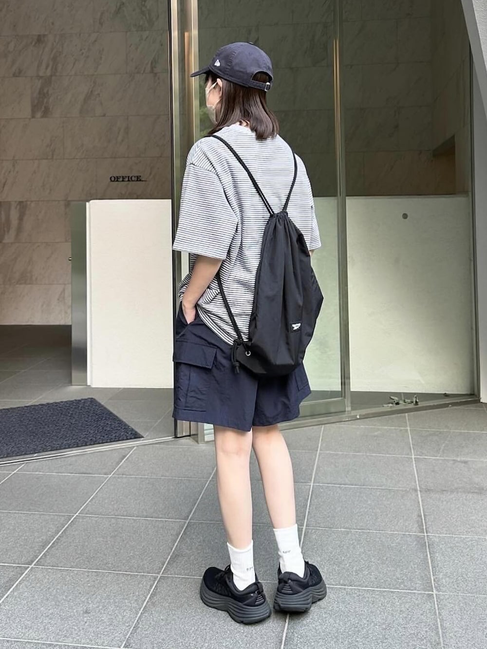 グレー系のTシャツ/カットソー、ブルー系のカーゴパンツ、ブラック系のスニーカーを着用したレディースの春コーディネートの2枚目の写真