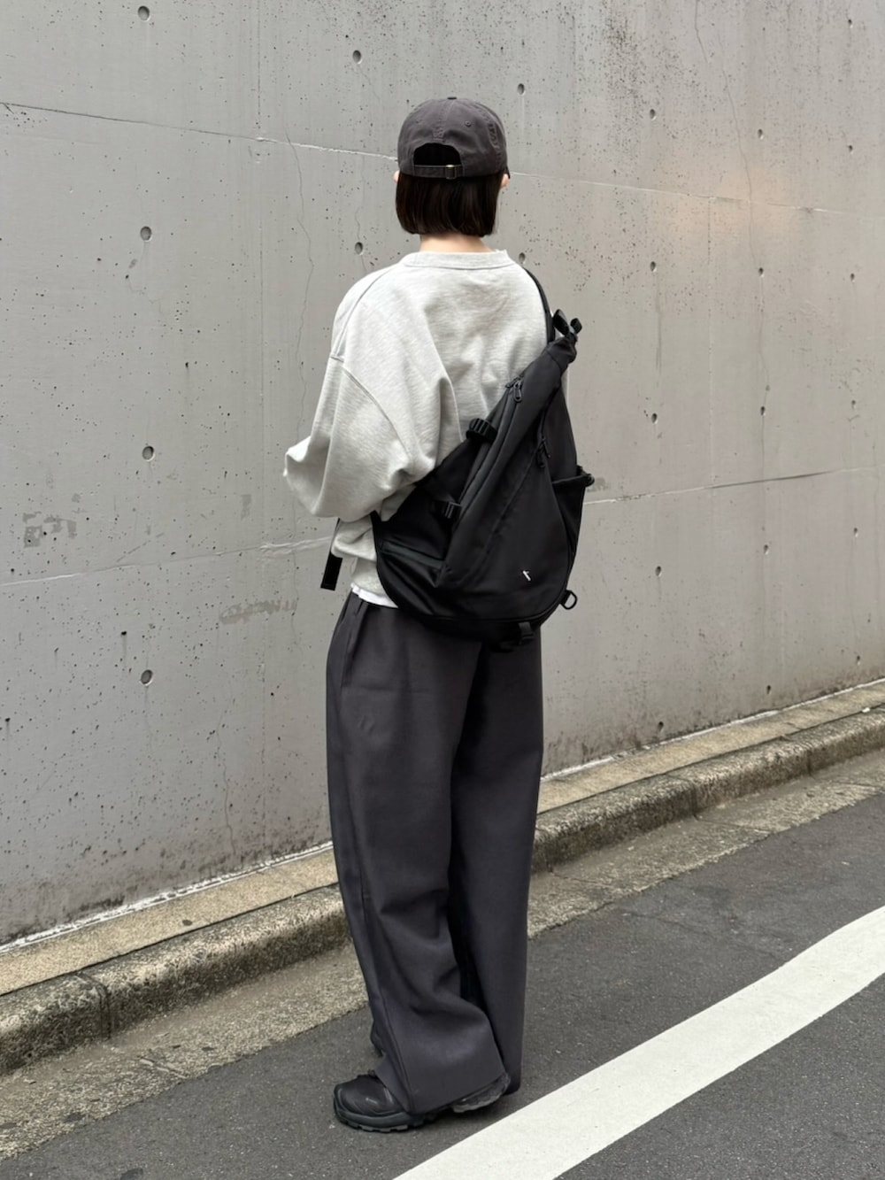 ブラック系のスニーカー、ブラック系のショルダーバッグ、グレー系のスウェットを着用したレディースの秋コーディネートの2枚目の写真