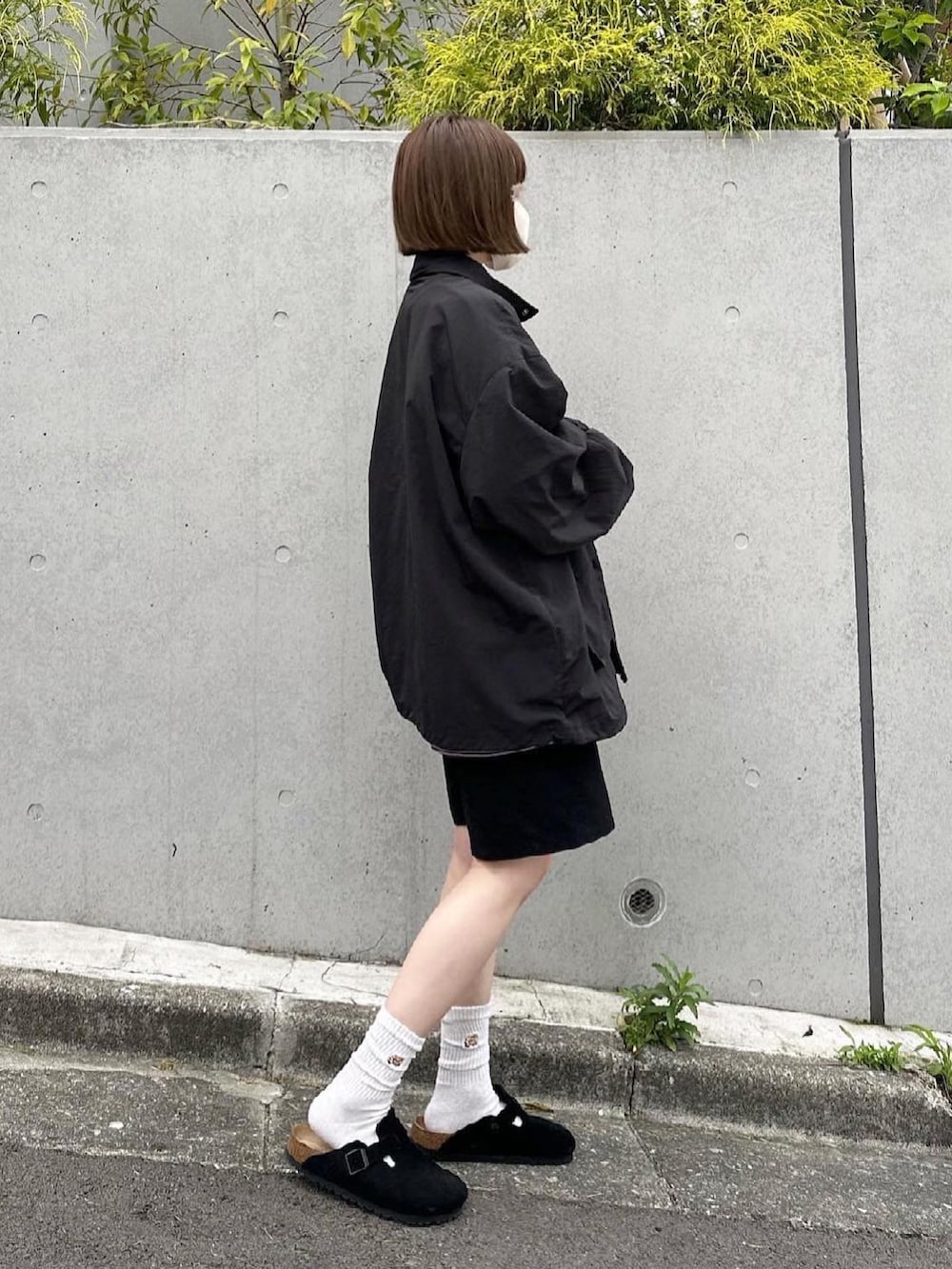 ブラック系のナイロンジャケット、ブラック系のその他パンツを着用したレディースの春コーディネートの2枚目の写真