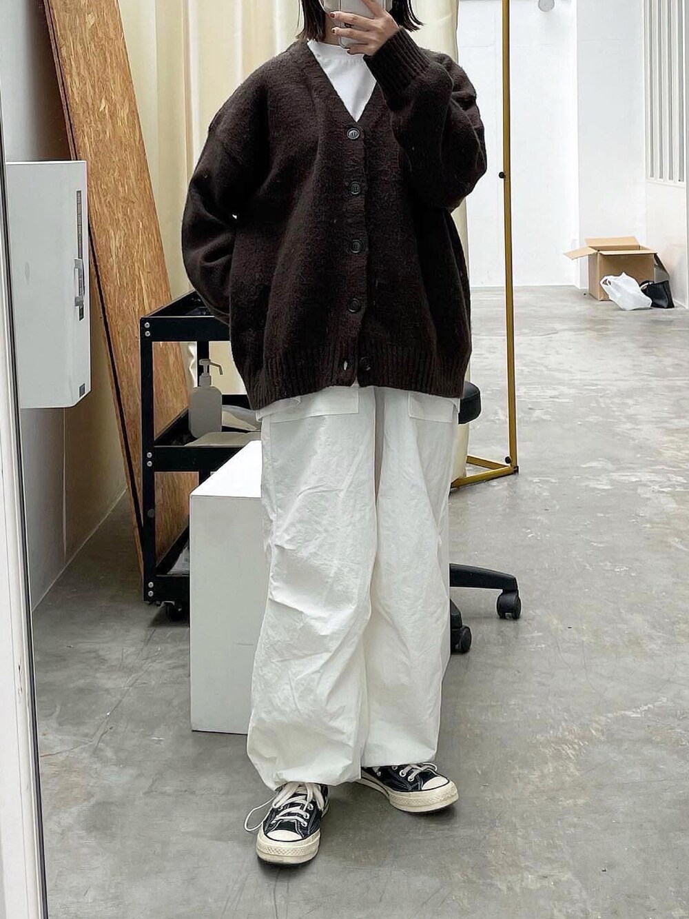 ブラウン系のカーディガン/ボレロ、ホワイト系のその他パンツ、ブラック系のスニーカーを着用したレディースの秋コーディネートの2枚目の写真