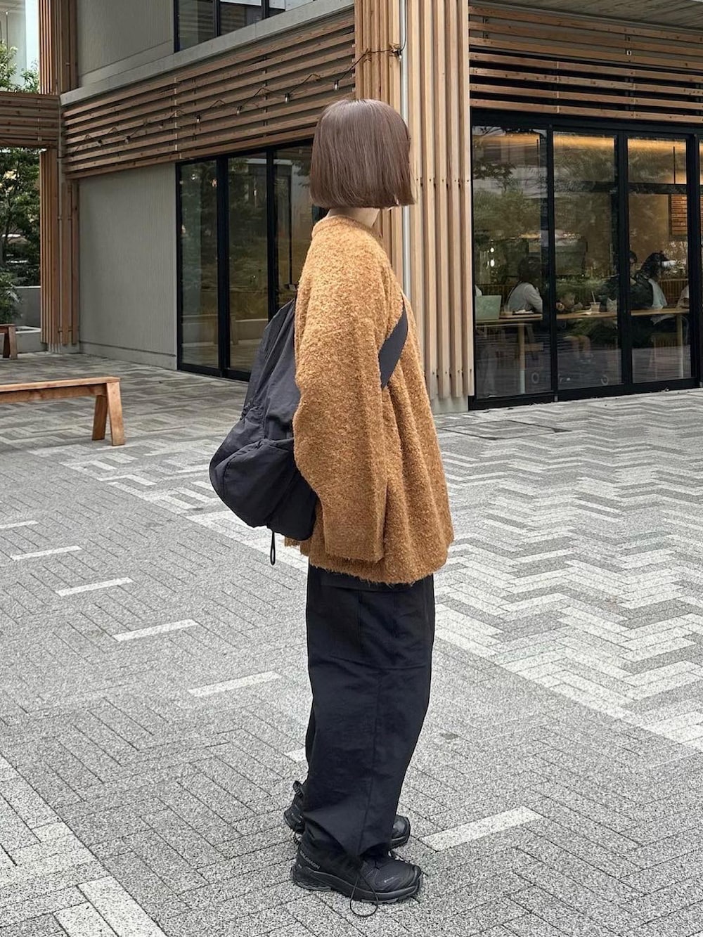 オレンジ系のカーディガン/ボレロ、ブラック系のカーゴパンツ、ブラック系のスニーカーを着用したレディースの秋コーディネートの4枚目の写真