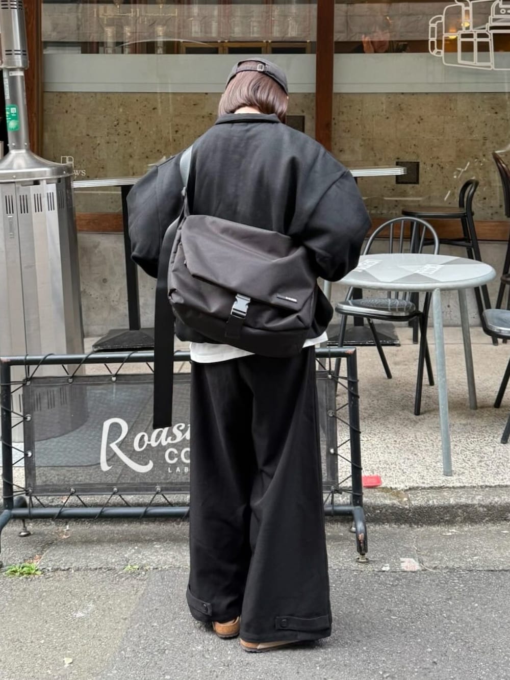 ブラック系のスウェット、ブラック系のスラックス、ブラック系のショルダーバッグを着用したレディースの冬コーディネートの2枚目の写真