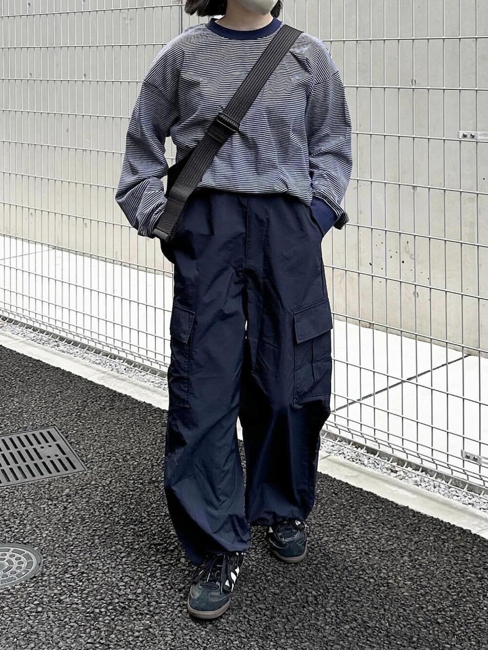 ブルー系のTシャツ/カットソー、ブルー系のカーゴパンツ、ブラック系のスニーカーを着用したレディースの春コーディネートの2枚目の写真