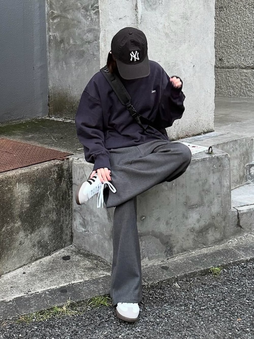 ブルー系のスウェット、グレー系のスラックス、ブラック系のショルダーバッグを着用したレディースの秋コーディネートの2枚目の写真