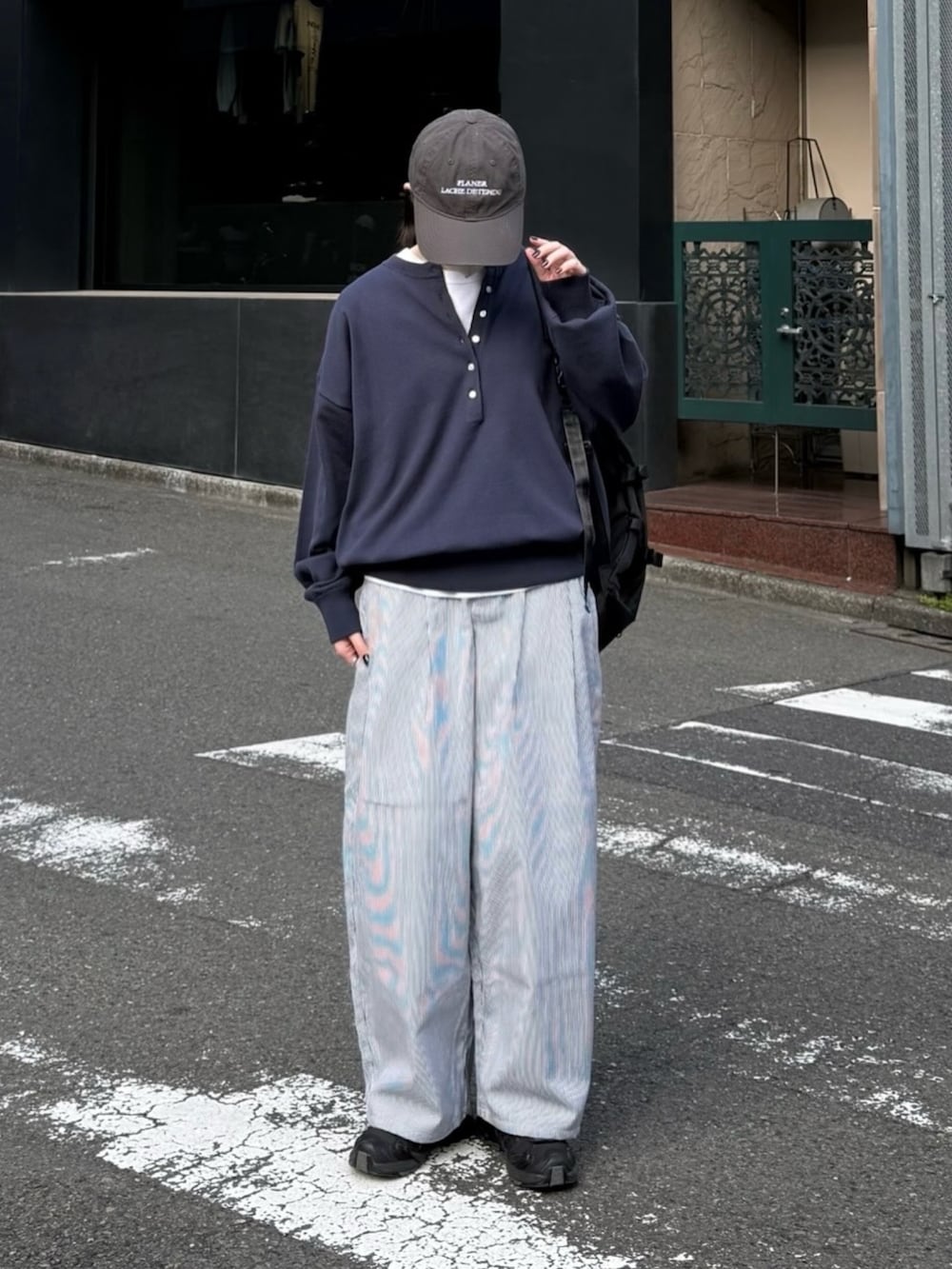 ブルー系のニット/セーター、ブラック系のスニーカー、ブラック系のショルダーバッグを着用したレディースの春コーディネートの2枚目の写真