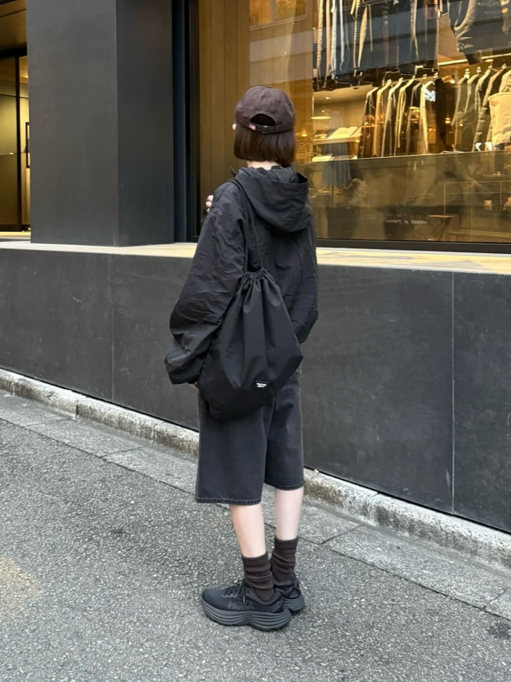 ブラック系のパーカー、ブラック系のスニーカー、ブラック系のデニムパンツを着用したレディースの秋コーディネートの3枚目の写真