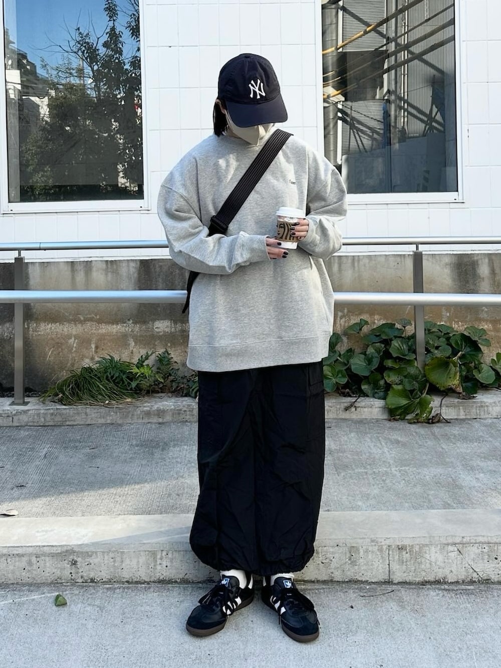 グレー系のスウェット、ブラック系のスカート、ブラック系のショルダーバッグを着用したレディースの春コーディネートの3枚目の写真