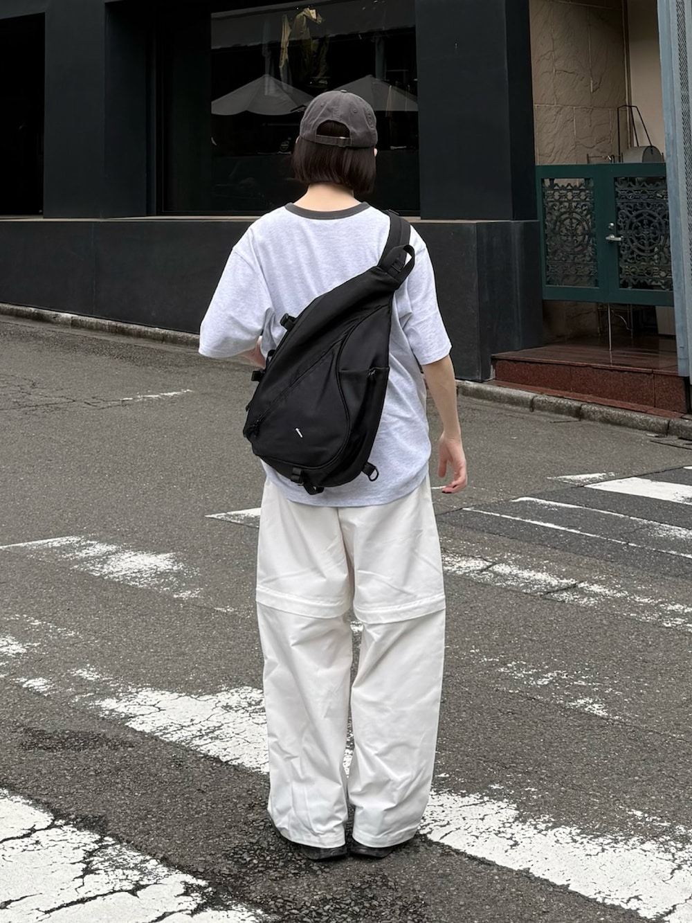 ホワイト系のその他パンツ、ブラック系のスニーカー、ブラック系のショルダーバッグを着用したレディースの夏コーディネートの2枚目の写真