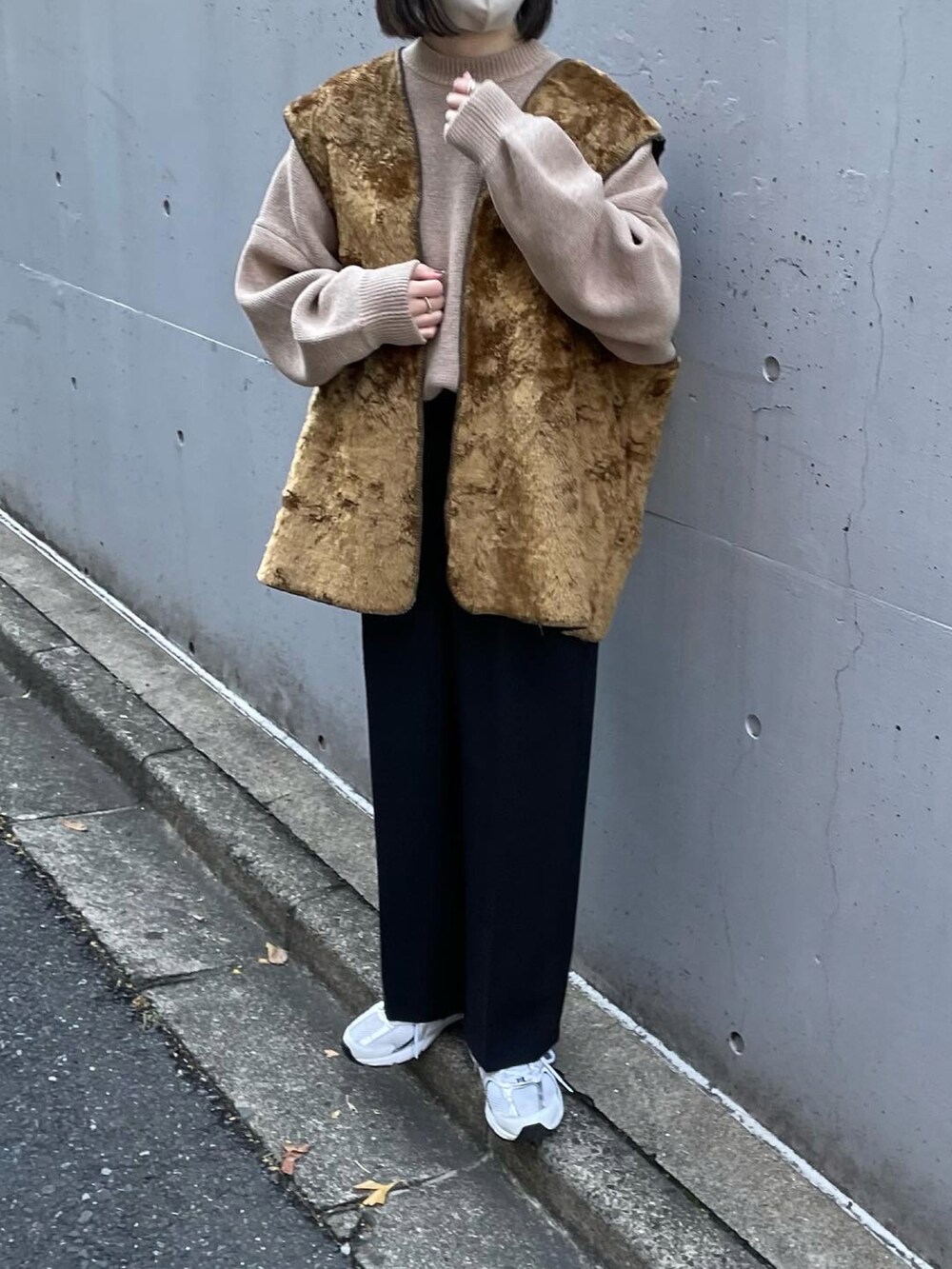 ベージュ系のニット/セーター、ブラック系のその他パンツ、ホワイト系のスニーカーを着用したレディースの冬コーディネートの2枚目の写真