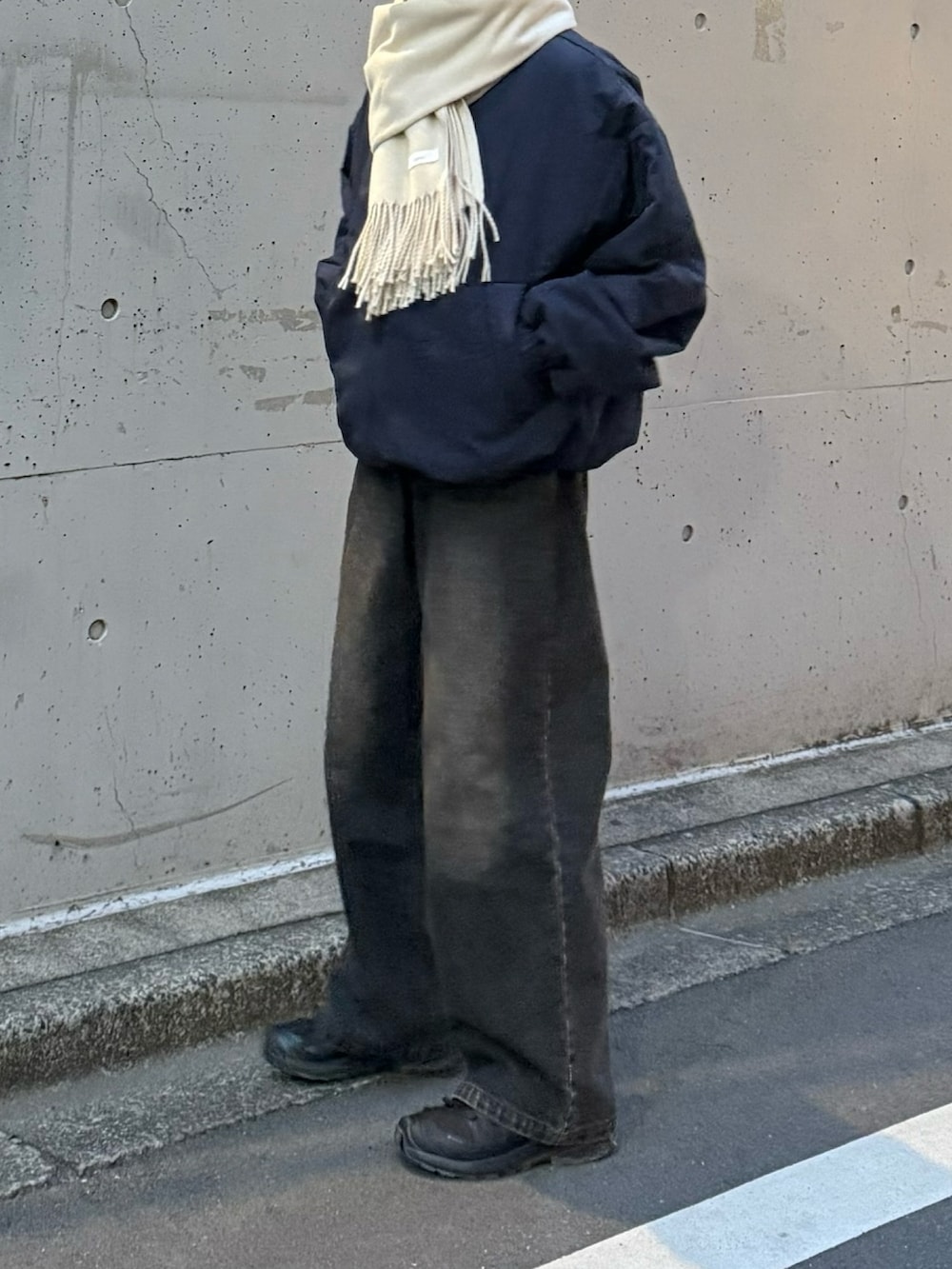 ブルー系のダウンジャケット/コート、ブラック系のスニーカー、ブラック系のデニムパンツを着用したレディースの冬コーディネートの2枚目の写真