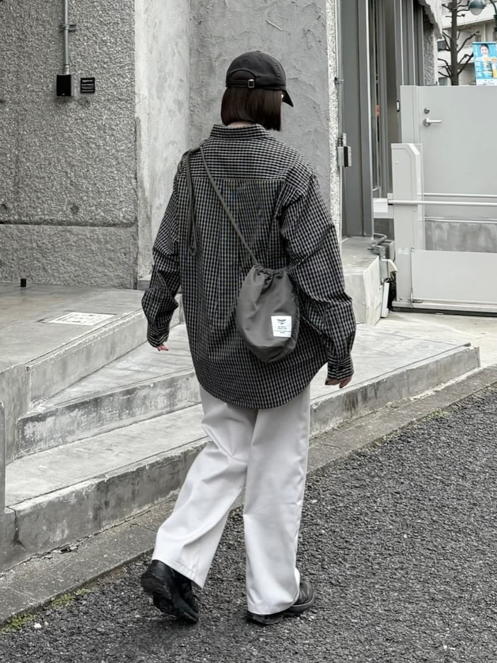 ブラック系のシャツ/ブラウス、ホワイト系のチノパンツ、ブラック系のスニーカーを着用したレディースの春コーディネートの2枚目の写真