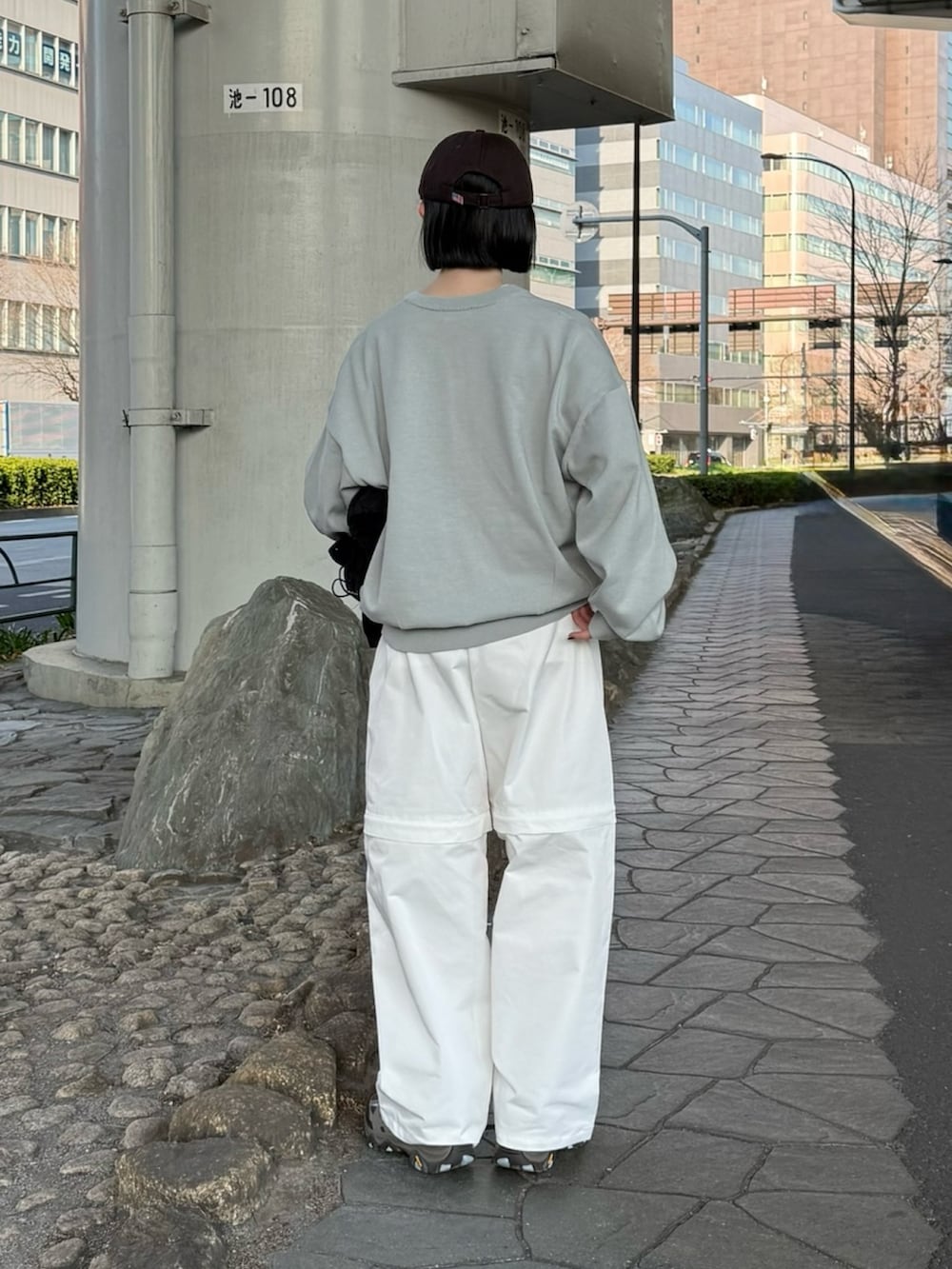 グレー系のスニーカー、グレー系のニット/セーター、ホワイト系のその他パンツを着用したレディースの春コーディネートの2枚目の写真