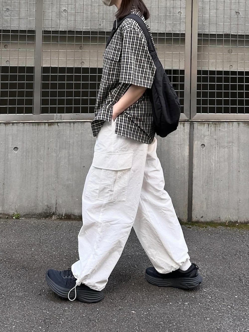 ブラック系のシャツ/ブラウス、ホワイト系のカーゴパンツ、ブラック系のスニーカーを着用したレディースの春コーディネートの2枚目の写真