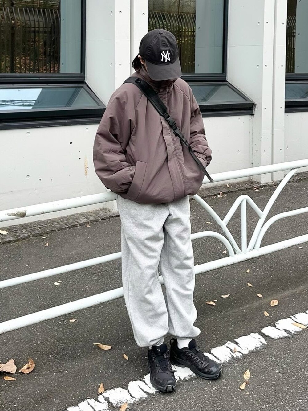 グレー系のその他アウター、グレー系のスウェットパンツ、ブラック系のショルダーバッグを着用したレディースの冬コーディネートの2枚目の写真