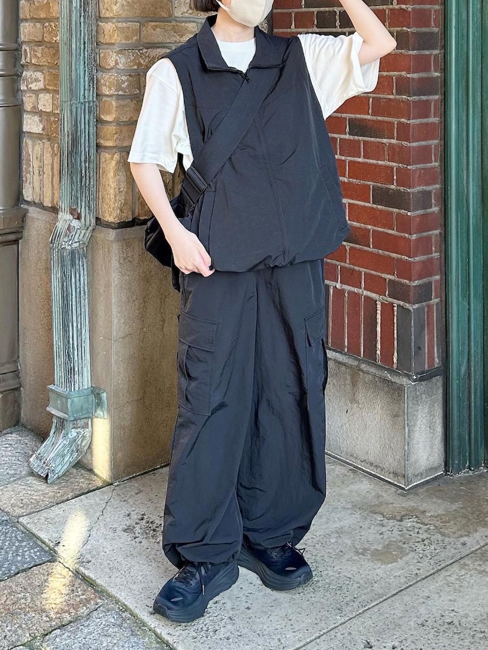 ブラック系のベスト、ブラック系のカーゴパンツ、ブラック系のスニーカーを着用したレディースの夏コーディネートの2枚目の写真