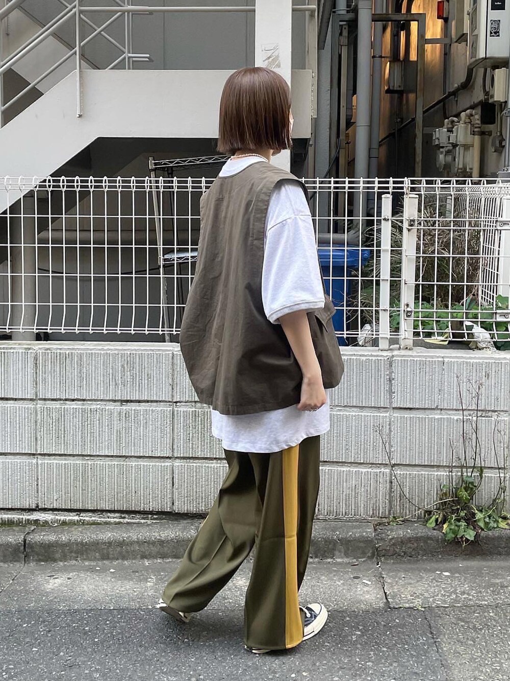 グレー系のベスト、グレー系のTシャツ/カットソー、グリーン系のその他パンツを着用したレディースの春コーディネートの2枚目の写真