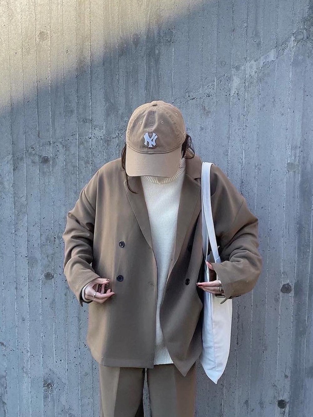 ベージュ系のテーラードジャケット、ベージュ系のニット/セーター、ベージュ系のその他パンツを着用したレディースの冬コーディネートの3枚目の写真