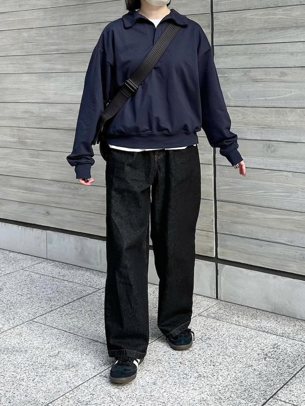 ブルー系のスウェット、ブラック系のデニムパンツ、ブラック系のショルダーバッグを着用したレディースの冬コーディネートの3枚目の写真