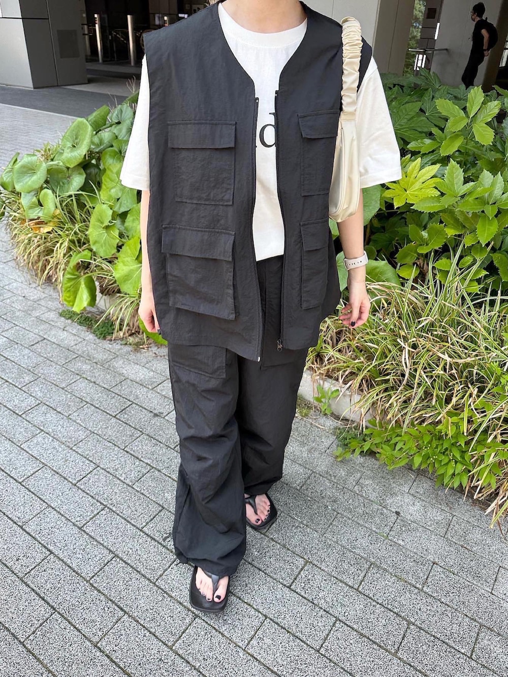 ブラック系のベスト、ブラック系のその他パンツ、ブラック系のサンダルを着用したレディースの夏コーディネートの3枚目の写真