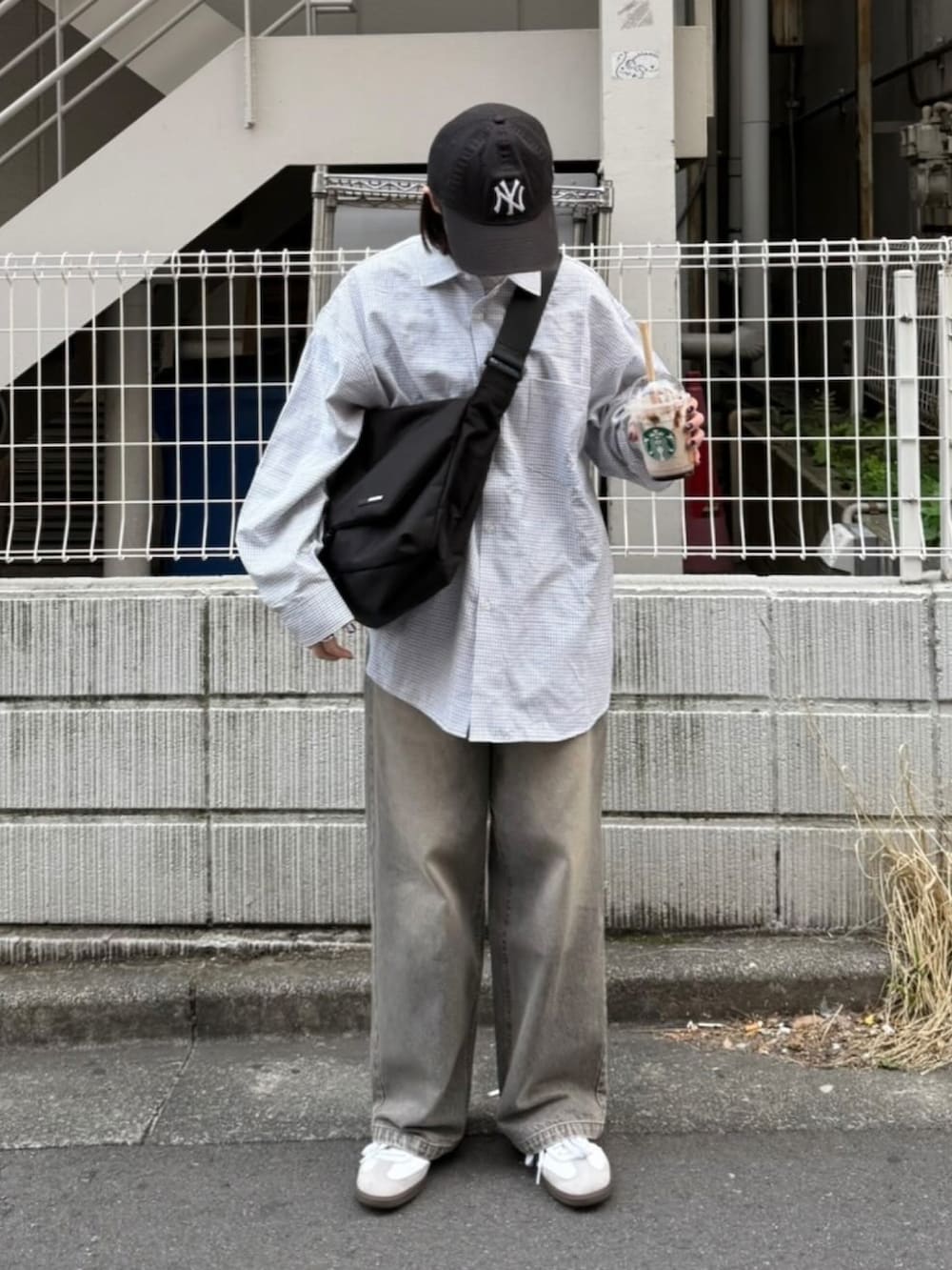 ブラック系のシャツ/ブラウス、グレー系のデニムパンツ、ブラック系のショルダーバッグを着用したレディースの春コーディネートの2枚目の写真