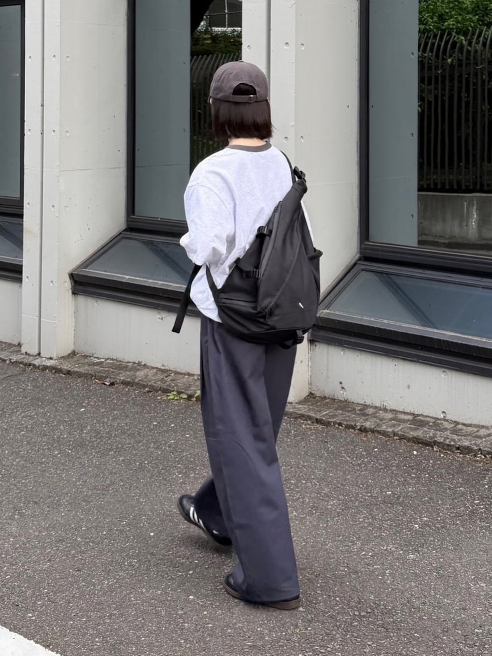 ブラック系のショルダーバッグ、ブラック系のスニーカー、グレー系のその他パンツを着用したレディースの春コーディネートの2枚目の写真