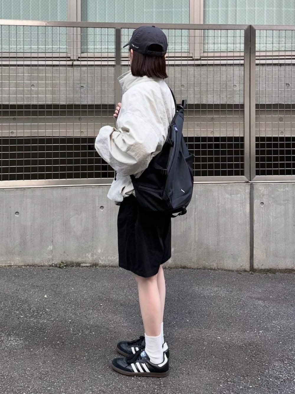 ホワイト系のマウンテンパーカー、ブラック系のその他パンツ、ブラック系のショルダーバッグを着用したレディースの秋コーディネートの2枚目の写真