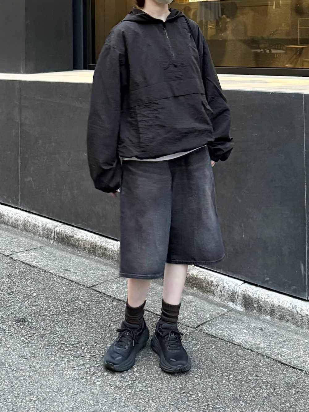 ブラック系のパーカー、ブラック系のスニーカー、ブラック系のデニムパンツを着用したレディースの秋コーディネートの2枚目の写真