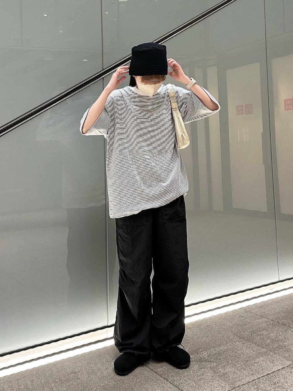 ホワイト系のTシャツ/カットソー、ブラック系のその他パンツ、ベージュ系のハンドバッグを着用したレディースの夏コーディネートの2枚目の写真