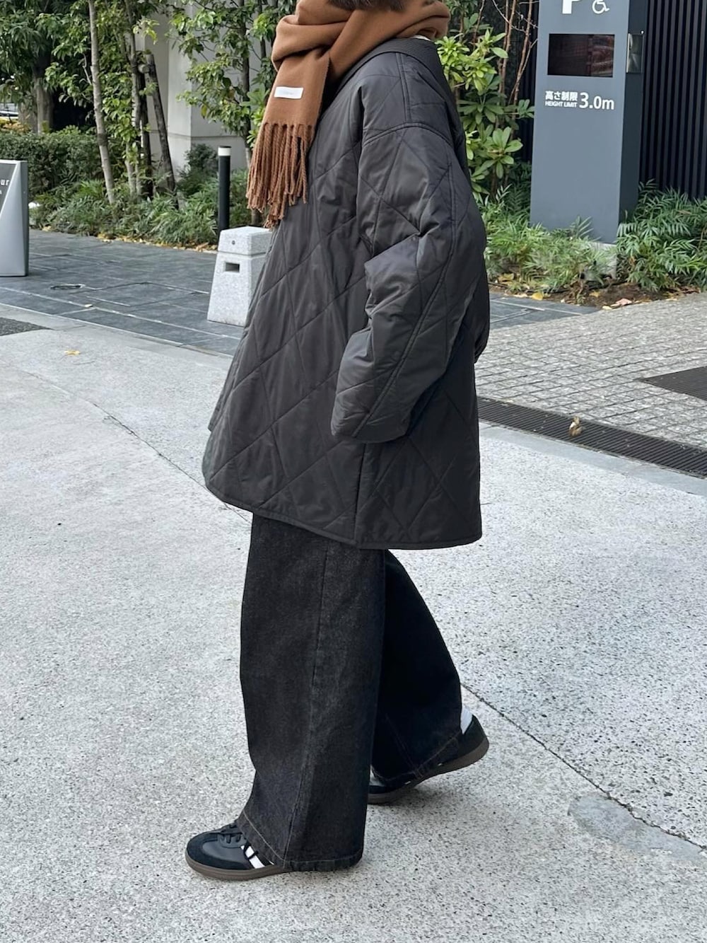 ブラック系のミリタリージャケット、ブラック系のデニムパンツ、ブラック系のショルダーバッグを着用したレディースの冬コーディネートの2枚目の写真