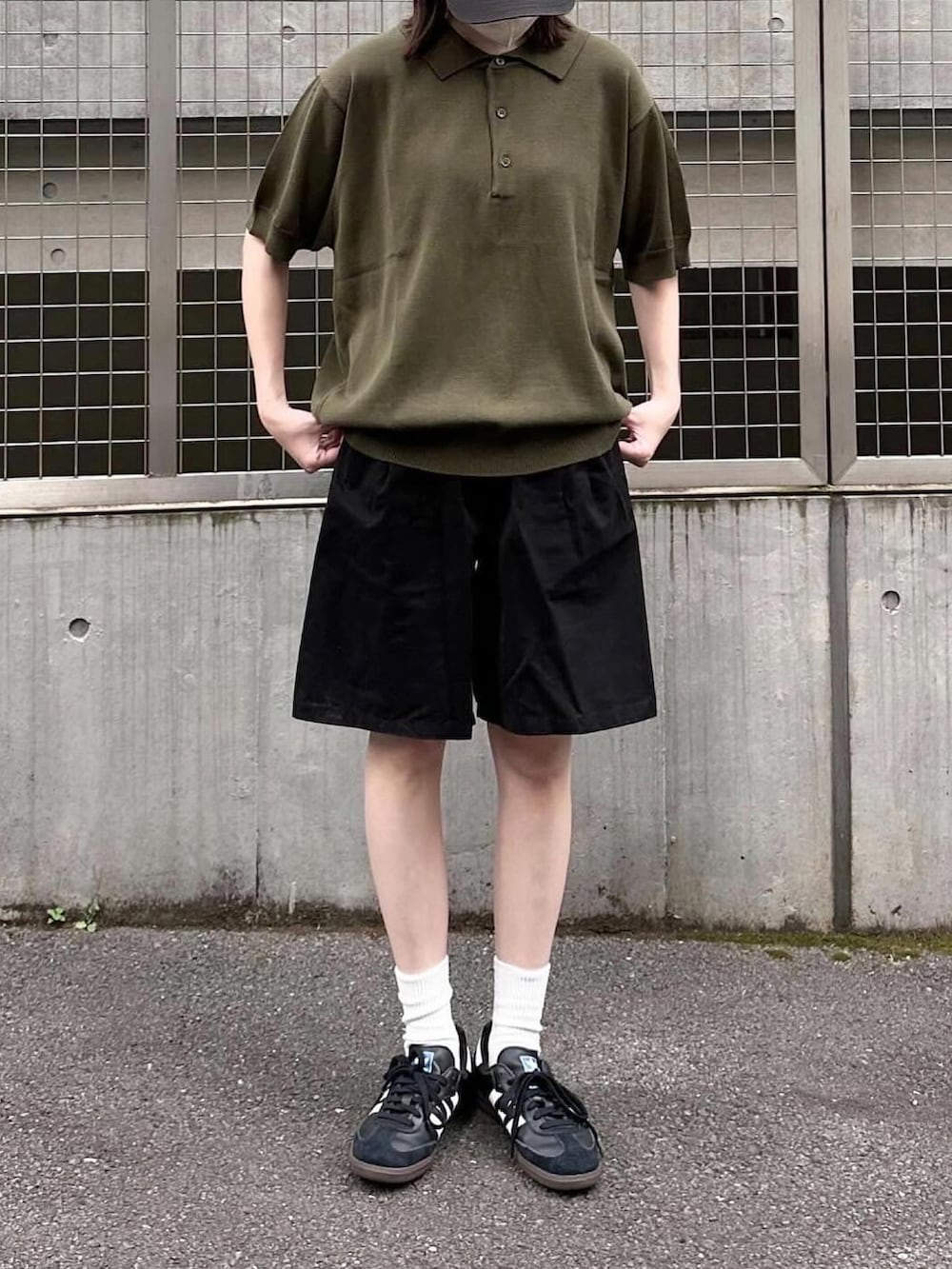 グリーン系のポロシャツ、ブラック系のその他パンツ、ブラック系のスニーカーを着用したレディースの夏コーディネートの2枚目の写真