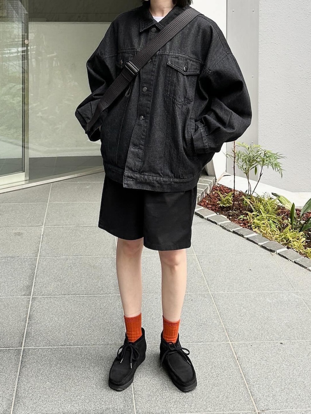 ブラック系のデニムジャケット、ブラック系のその他パンツ、ブラック系のショルダーバッグを着用したレディースの春コーディネートの2枚目の写真