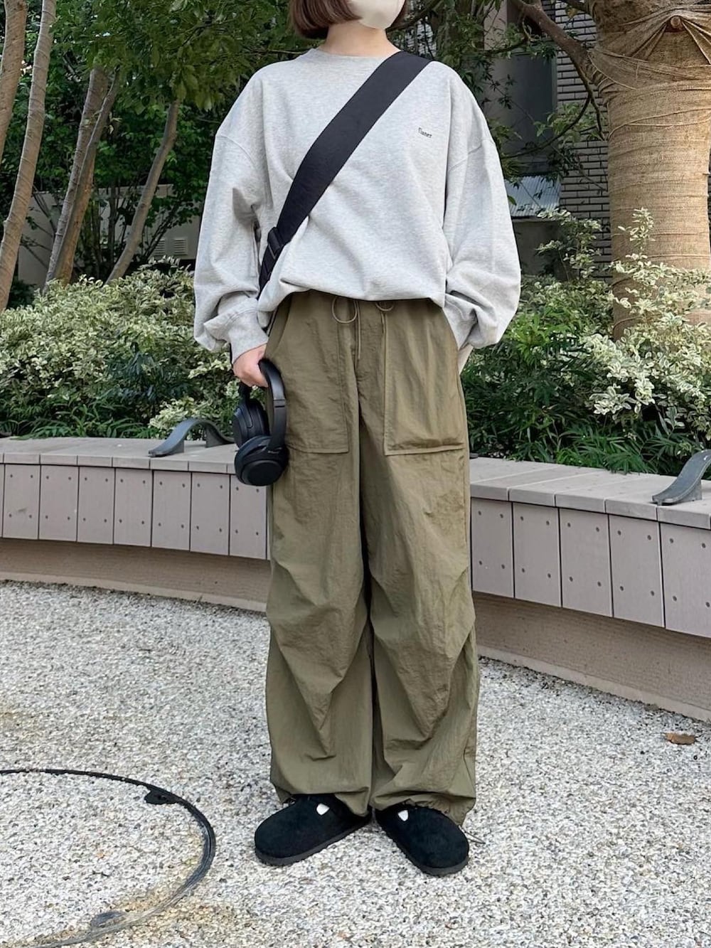 グレー系のスウェット、グリーン系のその他パンツ、ブラック系のサンダルを着用したレディースの秋コーディネートの2枚目の写真