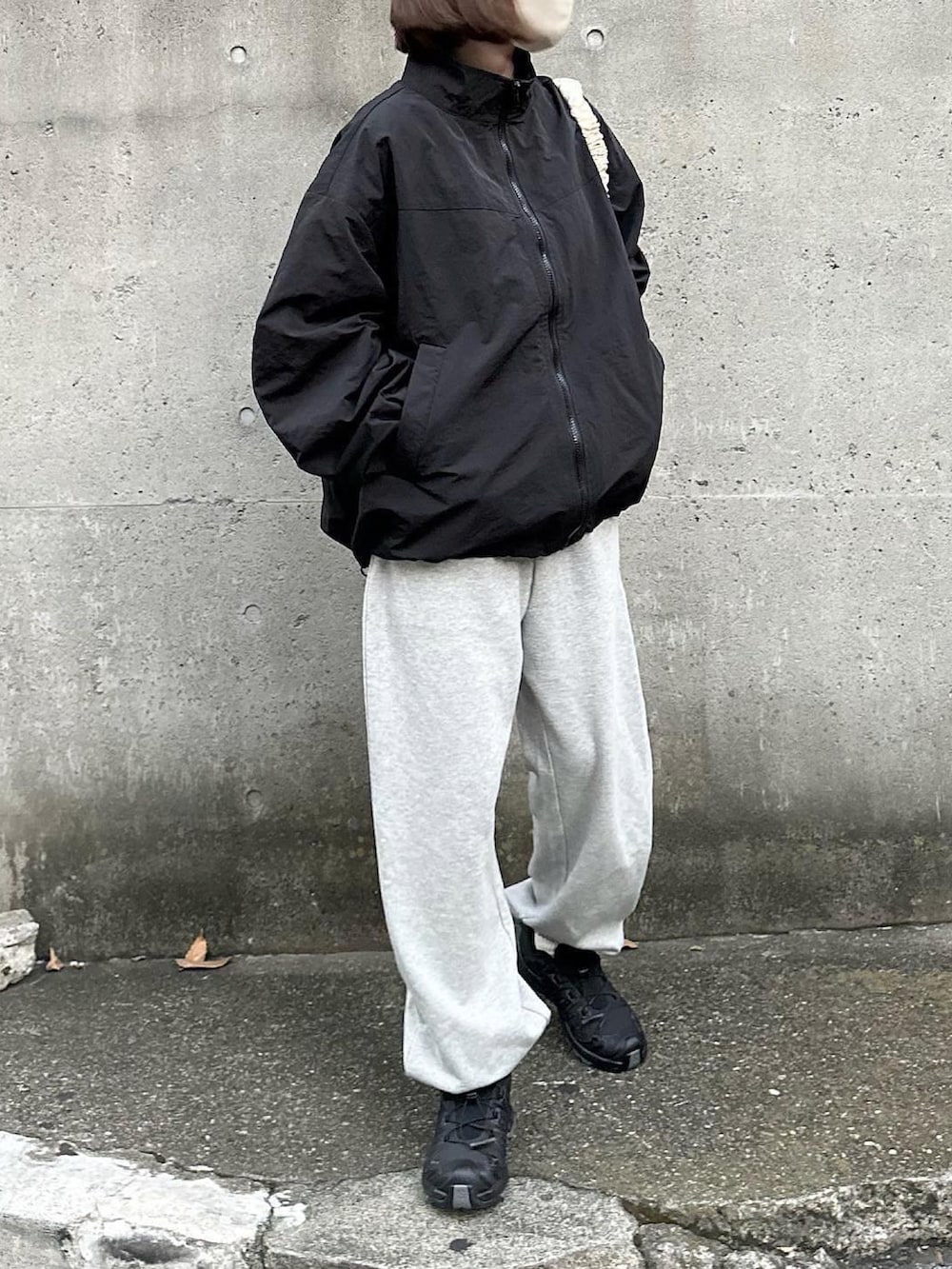 ブラック系のブルゾン、グレー系のスウェットパンツ、ブラック系のスニーカーを着用したレディースの秋コーディネートの2枚目の写真