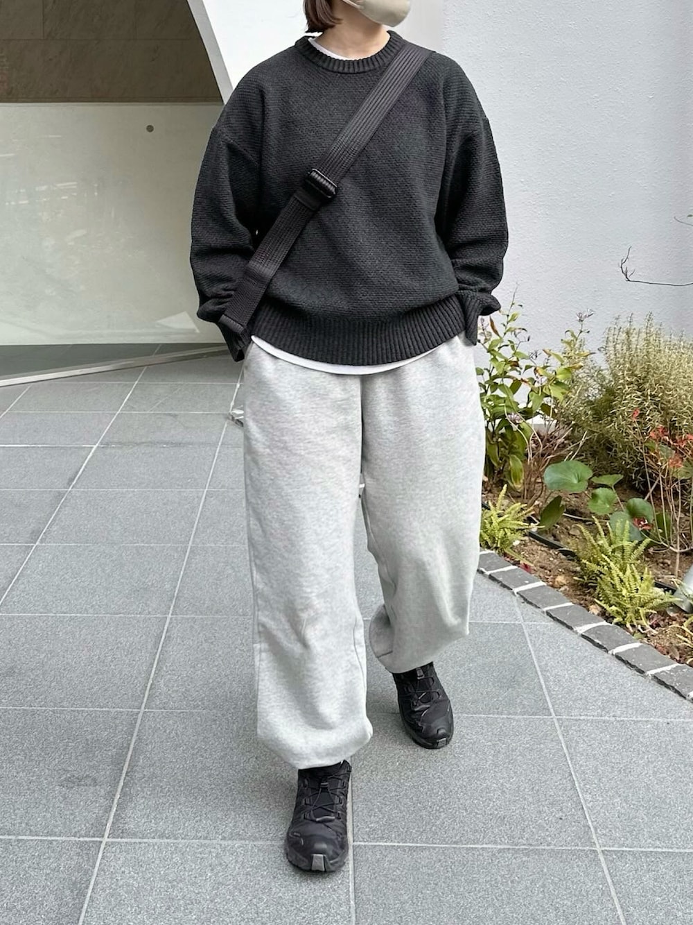 ブラック系のニット/セーター、グレー系のスウェットパンツ、ブラック系のスニーカーを着用したレディースの冬コーディネートの2枚目の写真